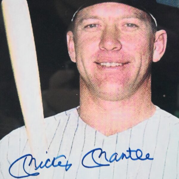 Close-up of the blue-ink signature reading Mickey Mantle across the jersey of the framed photograph