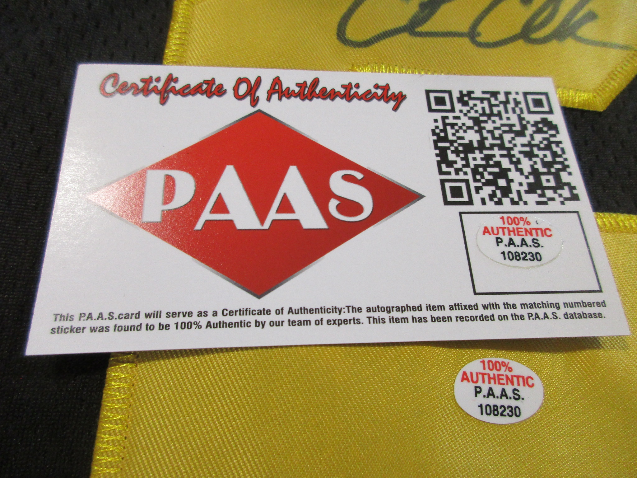 Close-up of a PAAS Certificate of Authenticity card with matching sticker number 108230 next to the signed jersey numeral