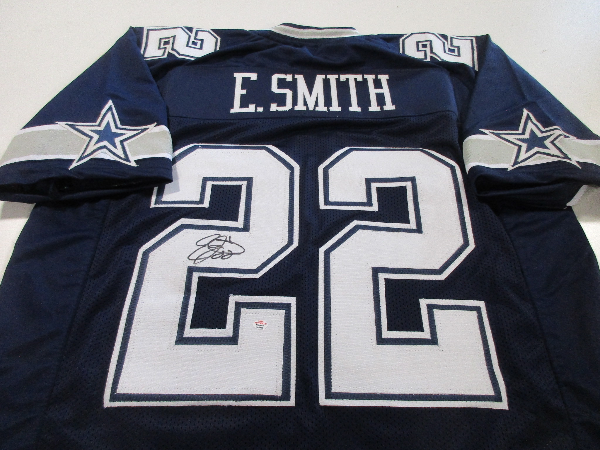 Navy blue Dallas Cowboys jersey with number 22, E. Smith nameplate, and a signature visible on the back numeral