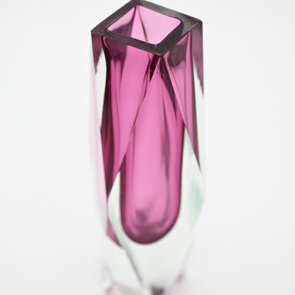 Overhead angled view into faceted pink glass vase opening showing color layering