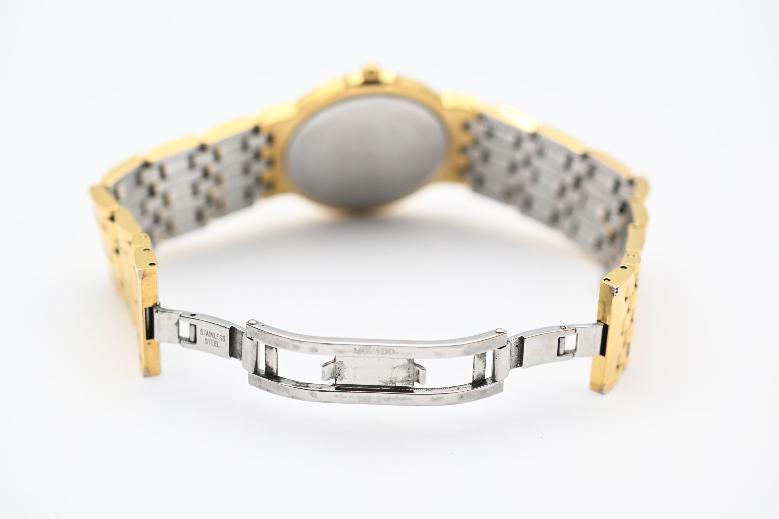 Open bracelet clasp showing engraved MOVADO and STAINLESS STEEL markings
