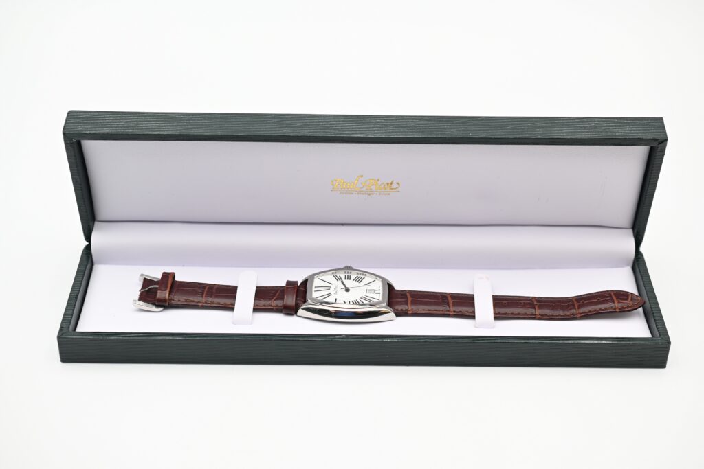 Paul Picot watch displayed open in a green textured presentation box