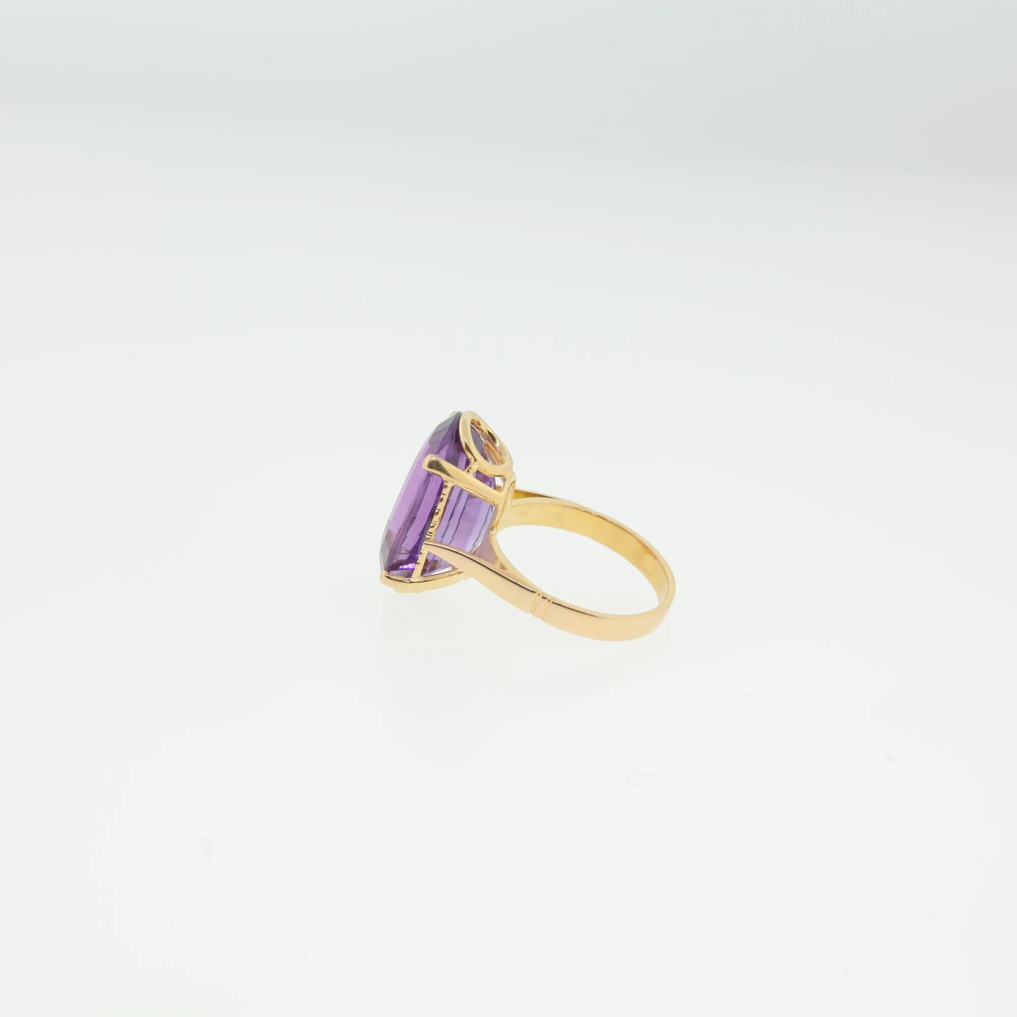 Angled side view showing pierced gallery beneath the purple gemstone