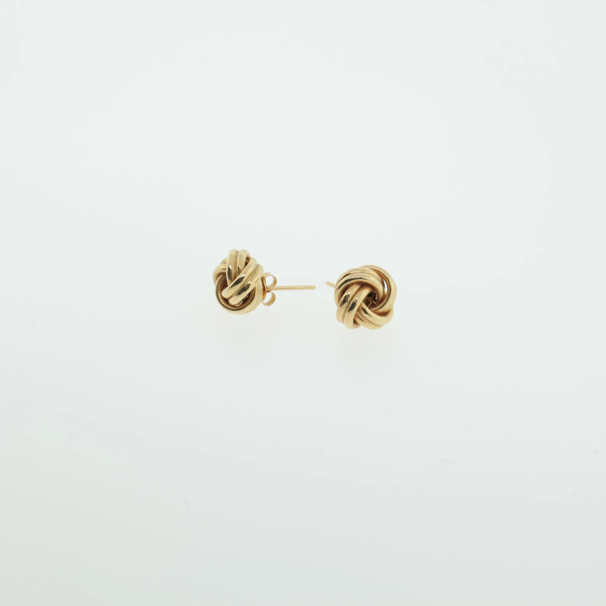 Front view of two matching gold-tone knot stud earrings on white background