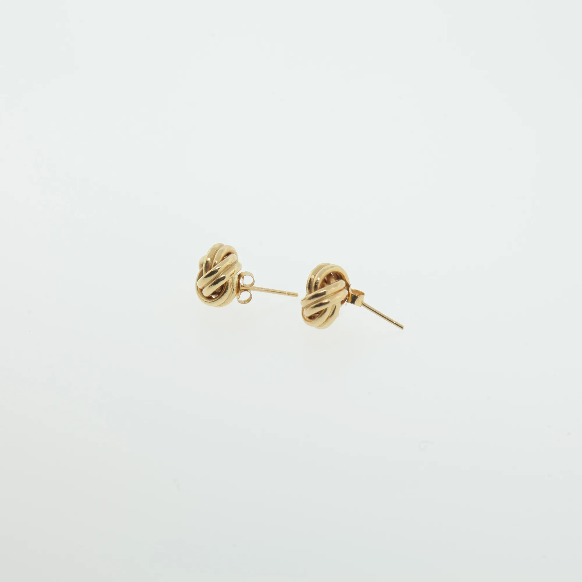 Angled view of love-knot stud earrings displaying post and butterfly backs
