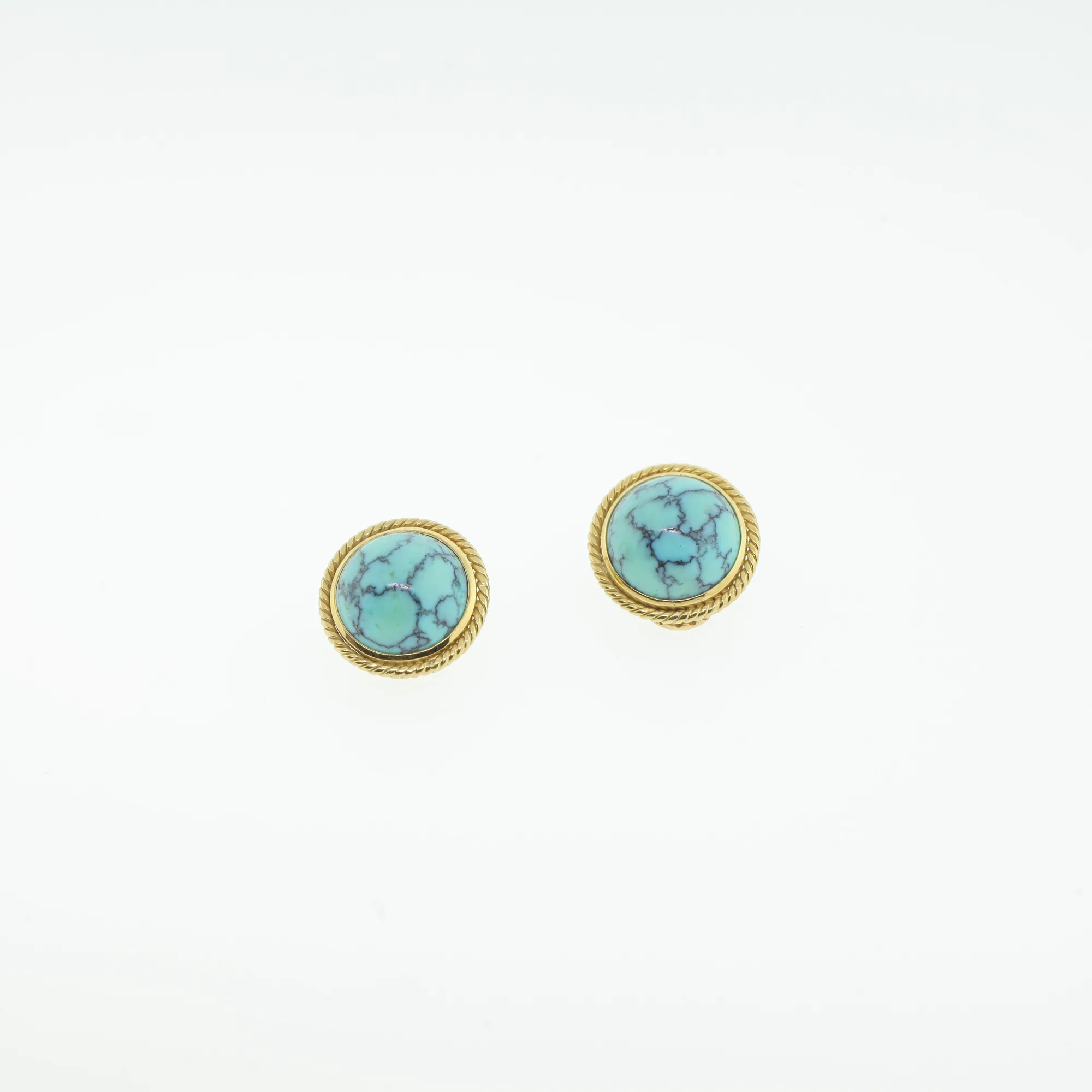 Close-up of the round turquoise-blue earrings against a white background