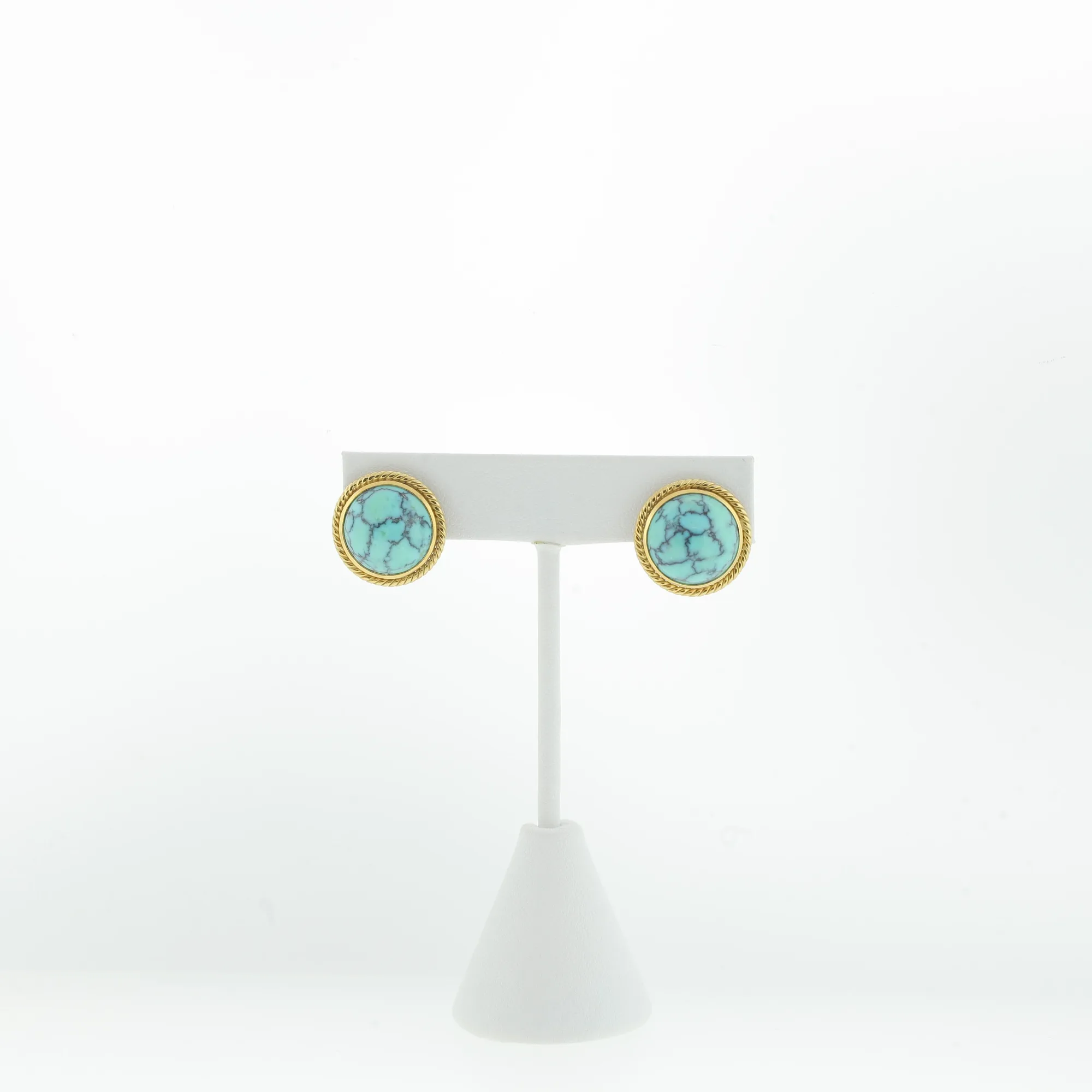 Front-facing view of the earrings on a white stand showing matching rope-edge bezels
