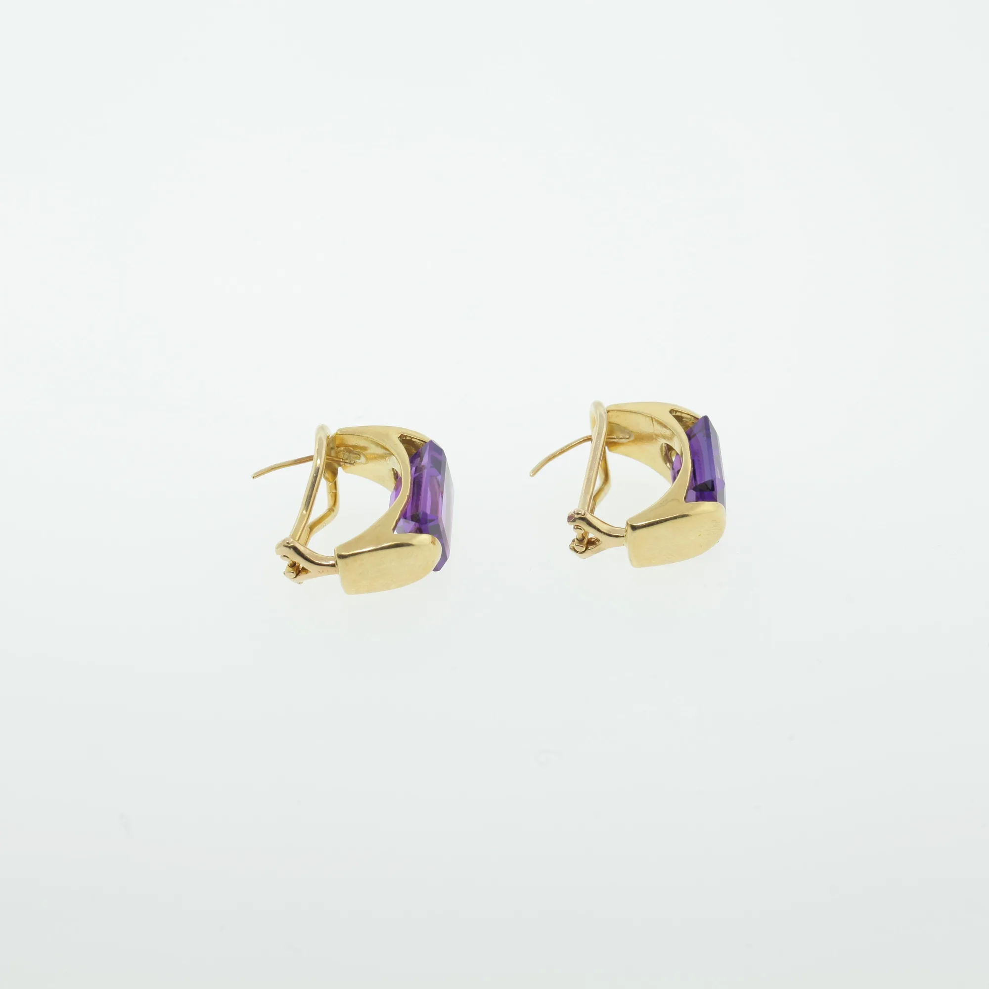 Back view of two gold-tone earrings showing hinged clip mechanisms and posts