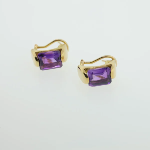 Front view of two gold-tone earrings with rectangular emerald-cut purple stones on a white background
