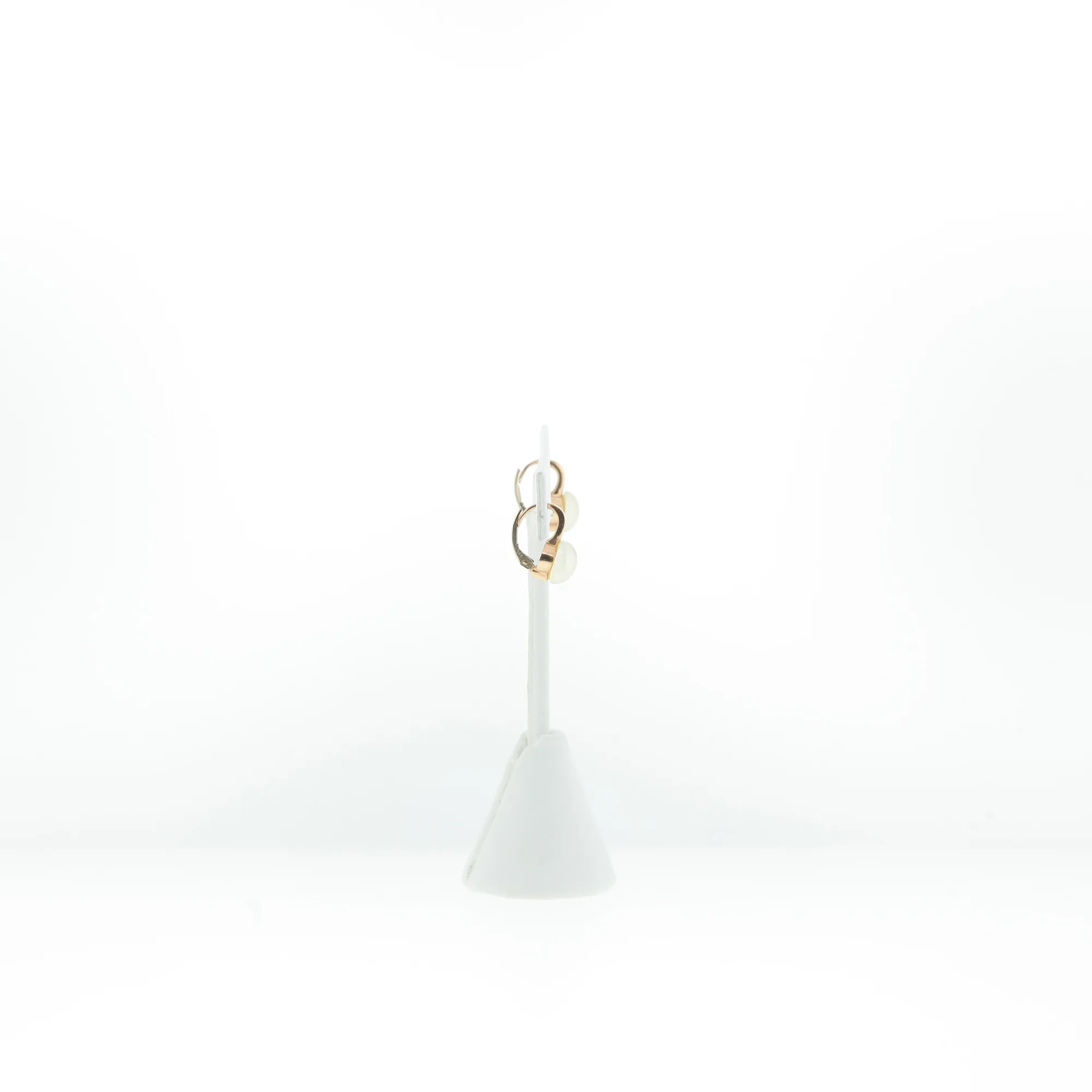Side view of earrings on jewelry stand showing hinge mechanism detail