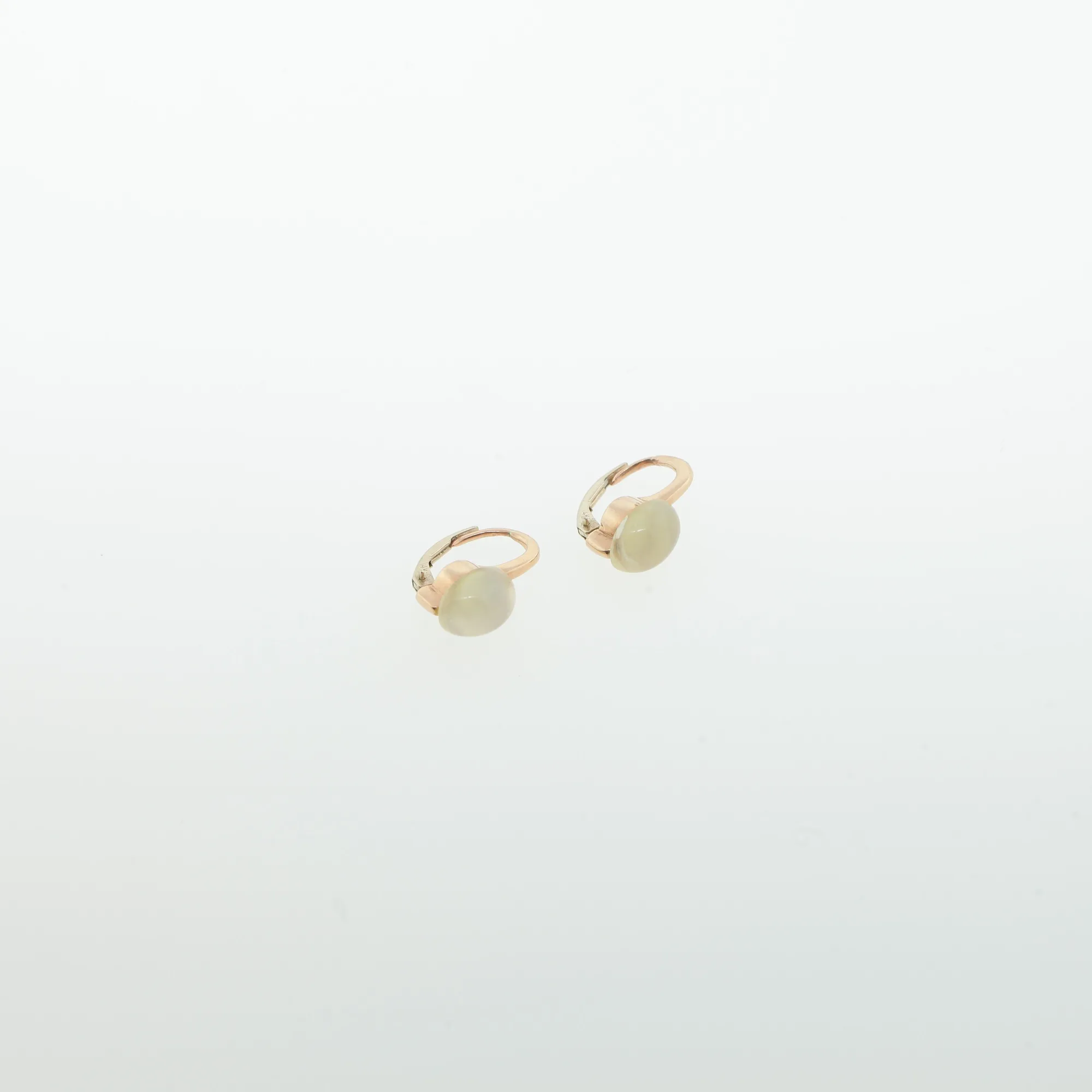 Angled close-up of both earrings showing the cabochon stones and rose gold hoop
