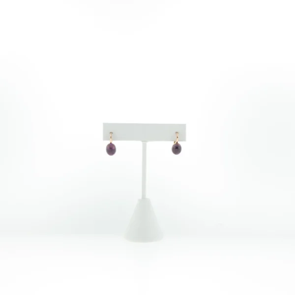 Front view of rose gold-tone drop earrings with oval purple cabochon stones on a white T-bar display stand