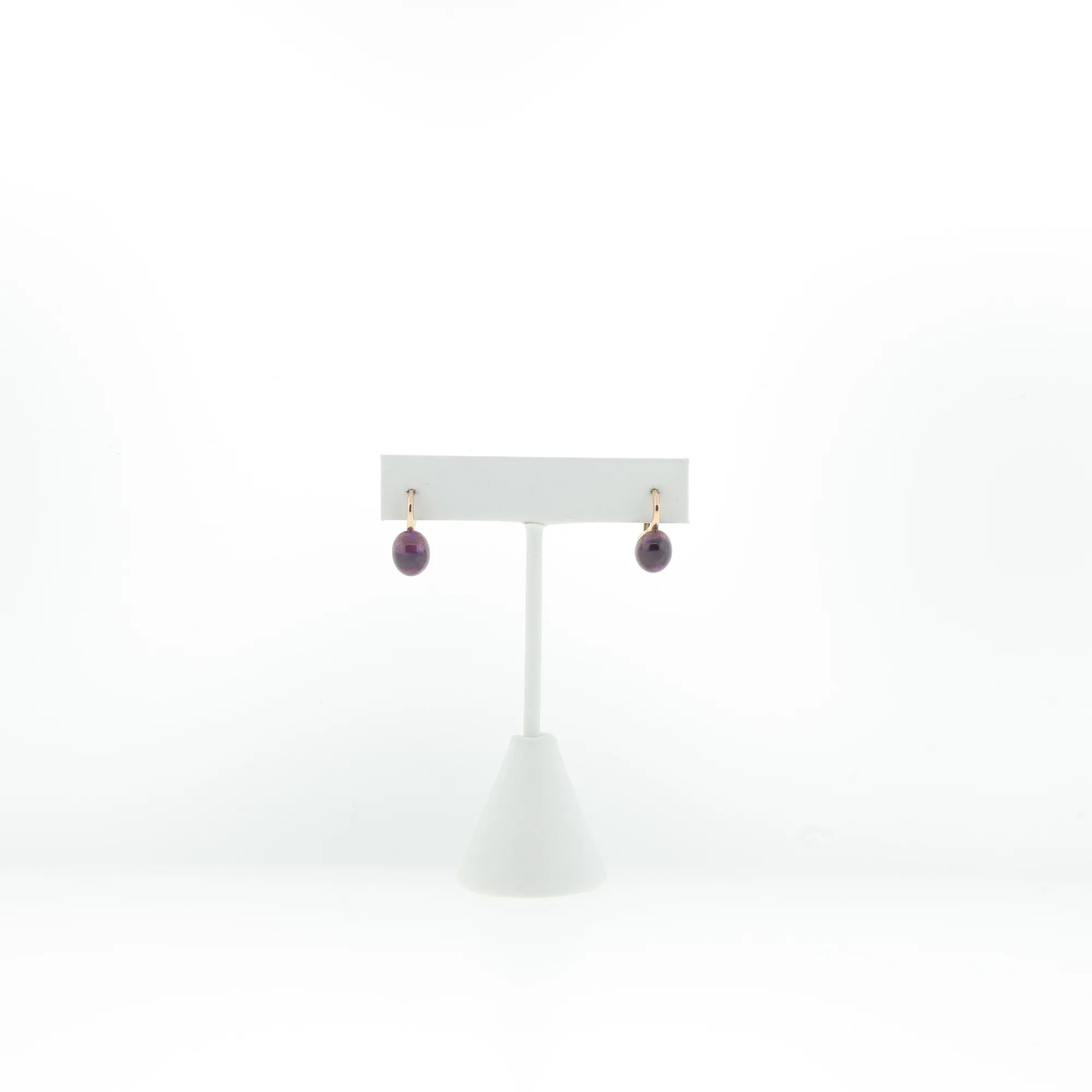 Front view of rose gold-tone drop earrings with oval purple cabochon stones on a white T-bar display stand