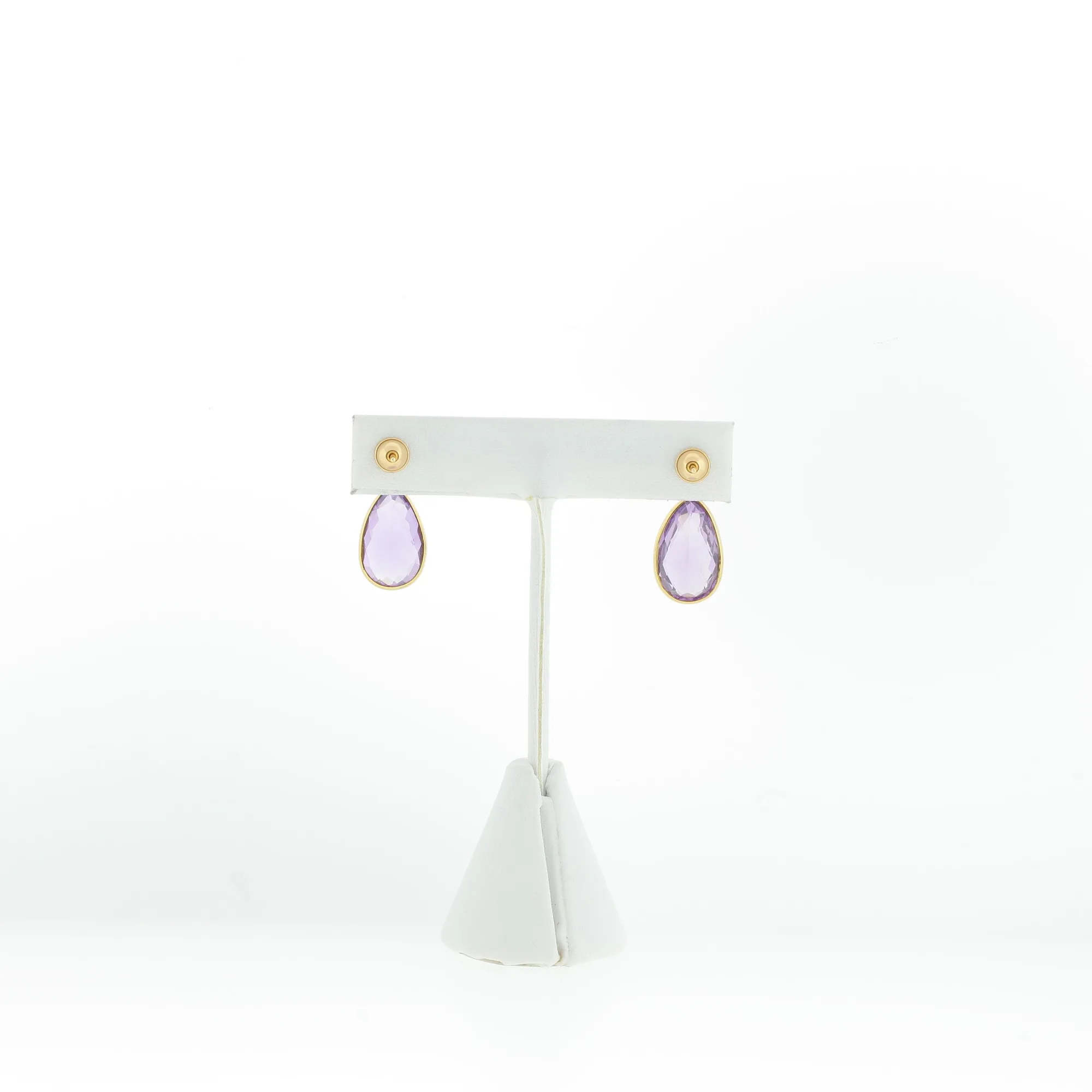 Pair of pear-shaped purple stone drop earrings displayed on a white earring stand