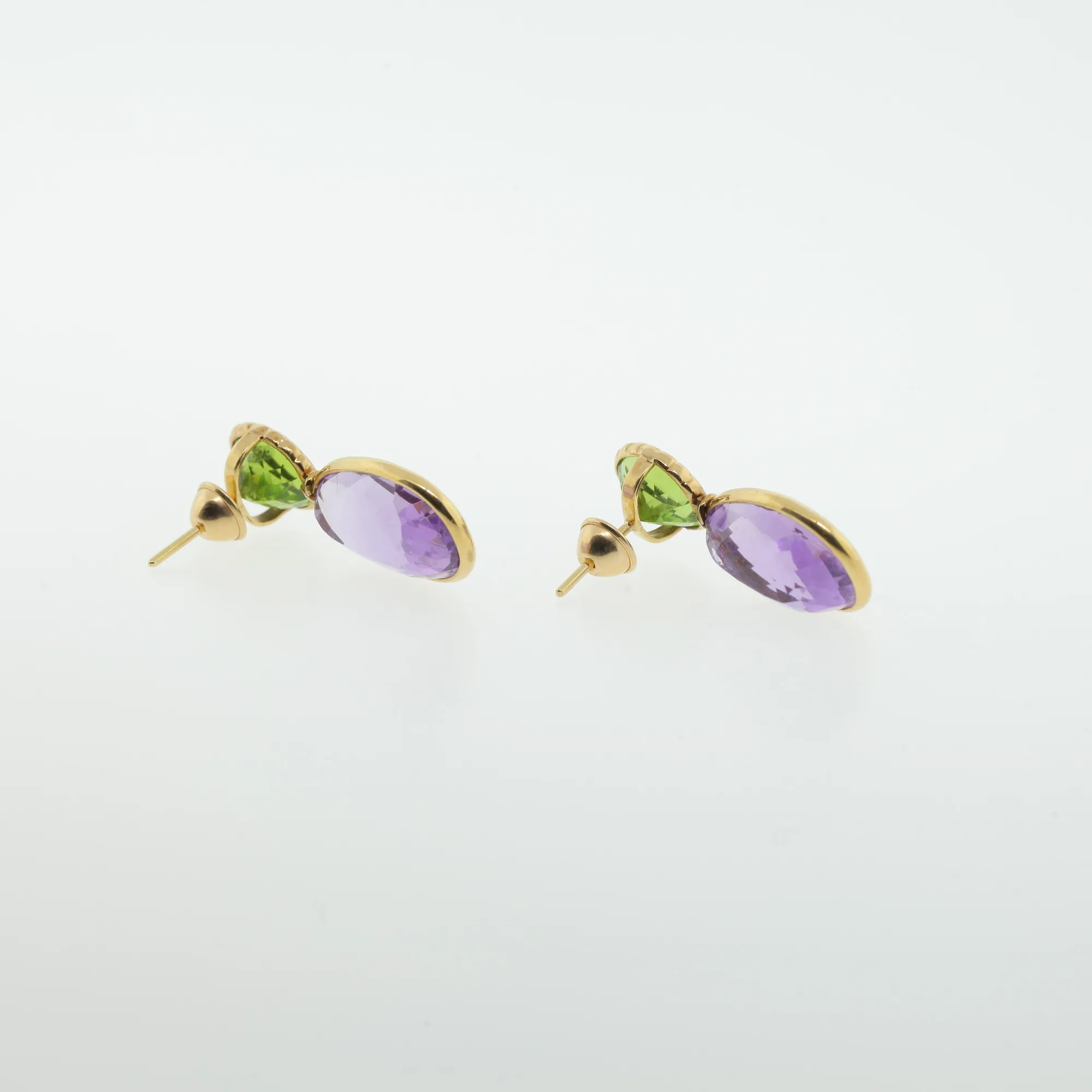 Side view of gold-tone drop earrings showing post backings and bezel-set stones