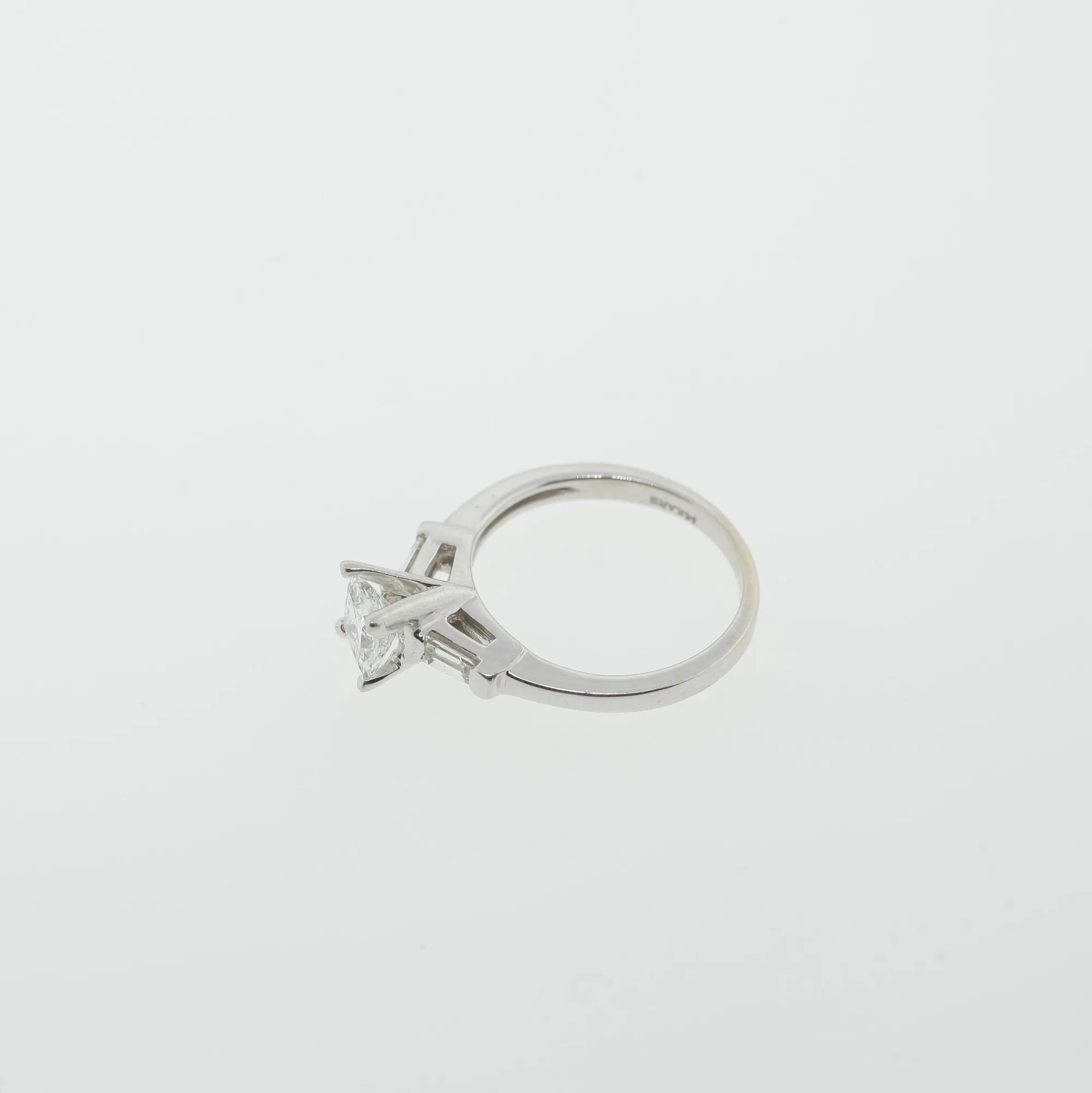Side profile of the ring showing the interior band stamp and openwork gallery beneath the center stone