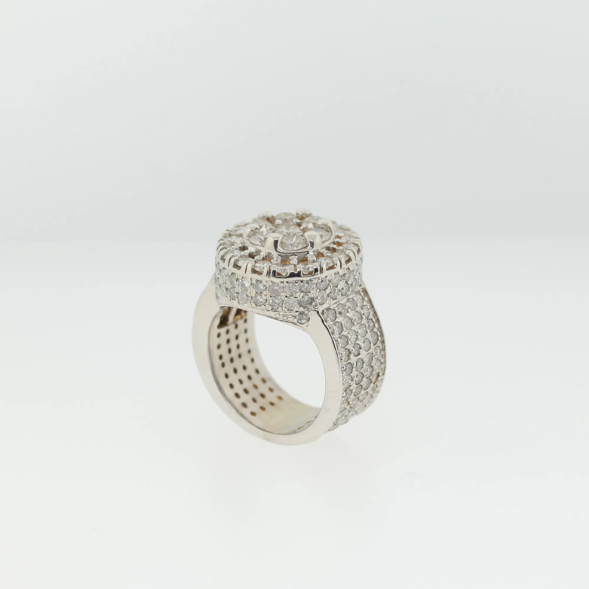 Side profile of ring showing round cluster halo top and pavé-covered shoulders and band