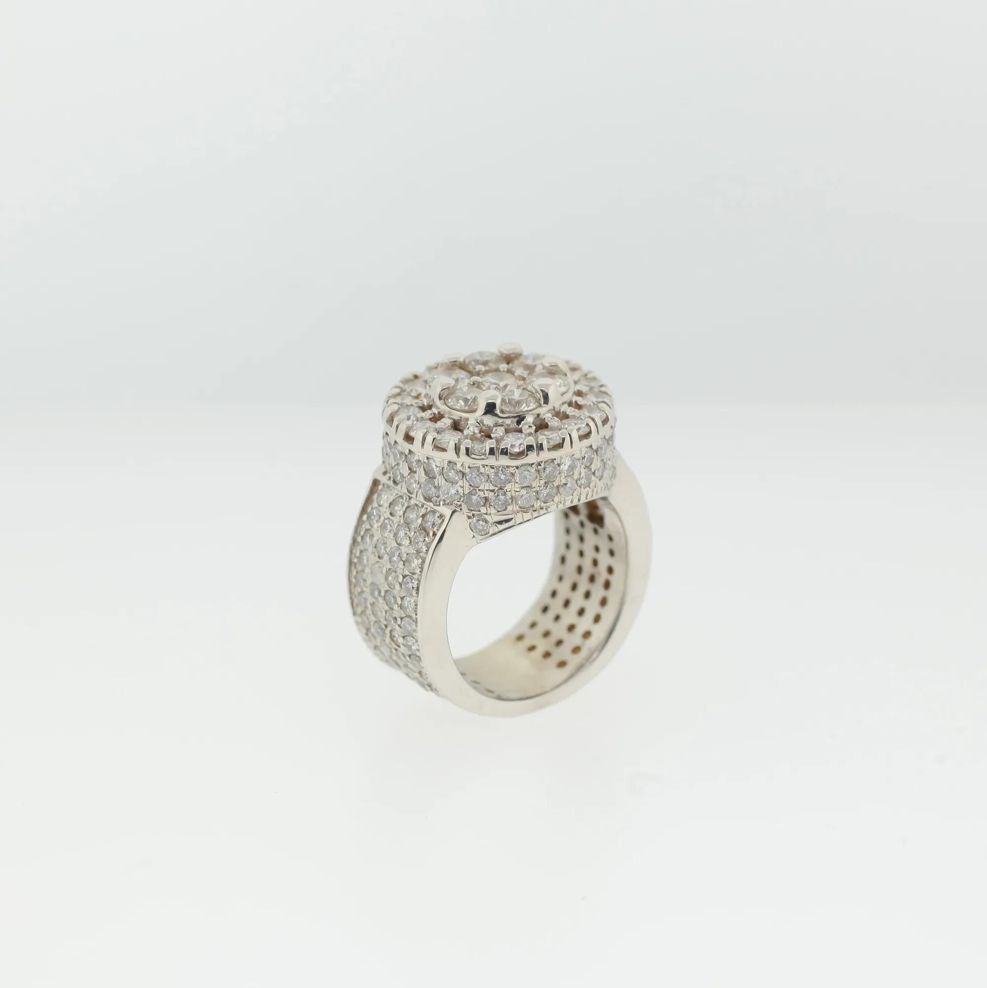 Front-facing angled view of ring highlighting the round cluster and halo of pavé stones