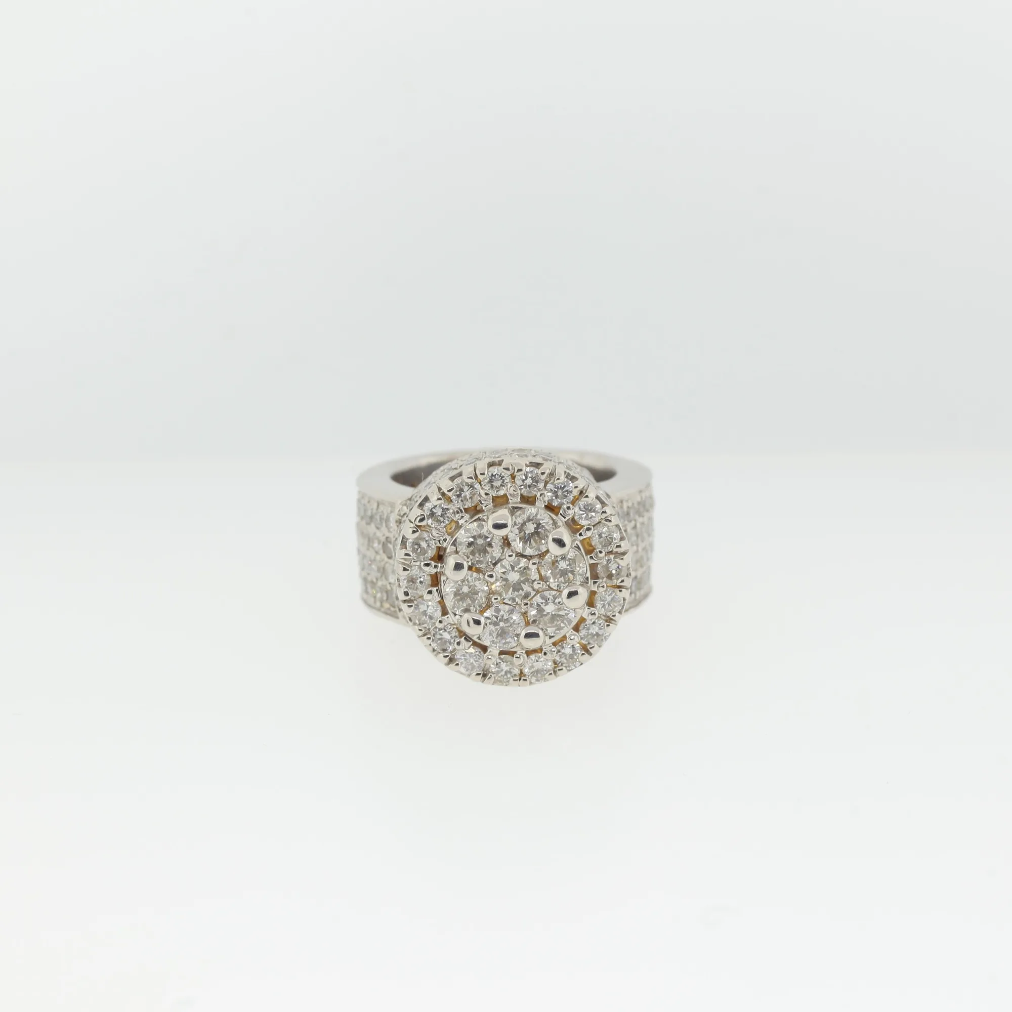 Straight-on front view of the ring's round cluster centerpiece surrounded by a diamond-pavé halo