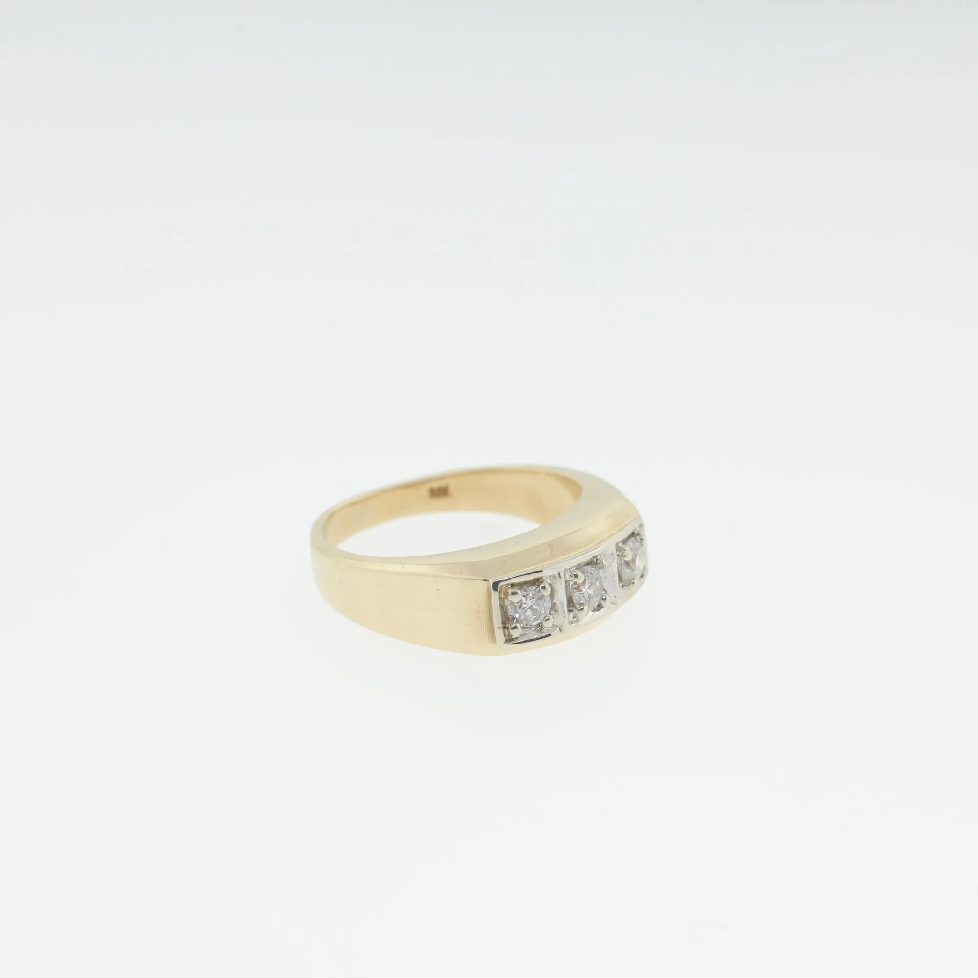 Angled view of a 10K yellow gold ring with three round stones set in a white metal channel