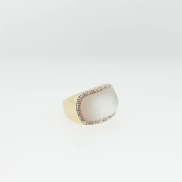 Angled view of a 14K gold ring with an oval cabochon stone bordered by small pavé stones