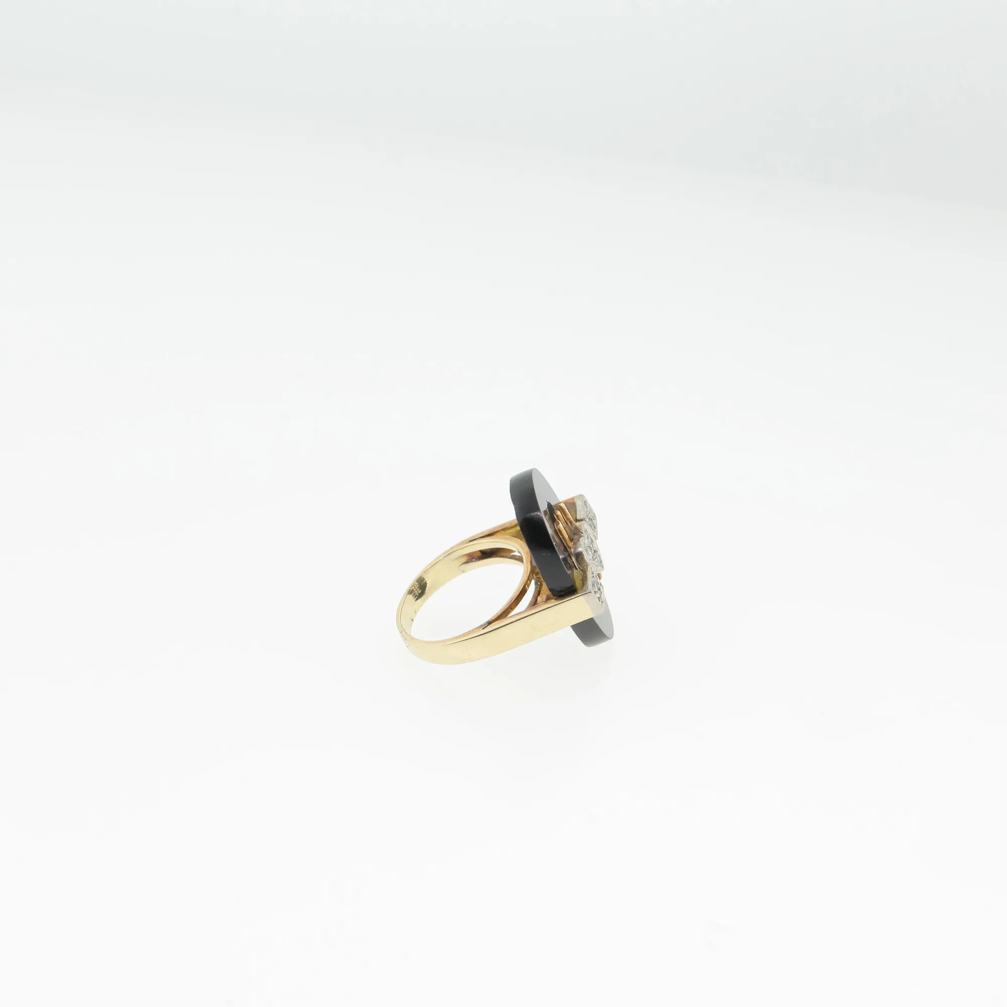 Angled side view of the ring showing the black stone disc and prong construction