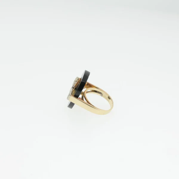 Side profile of a vintage cocktail ring showing the black stone disc and gold-tone band