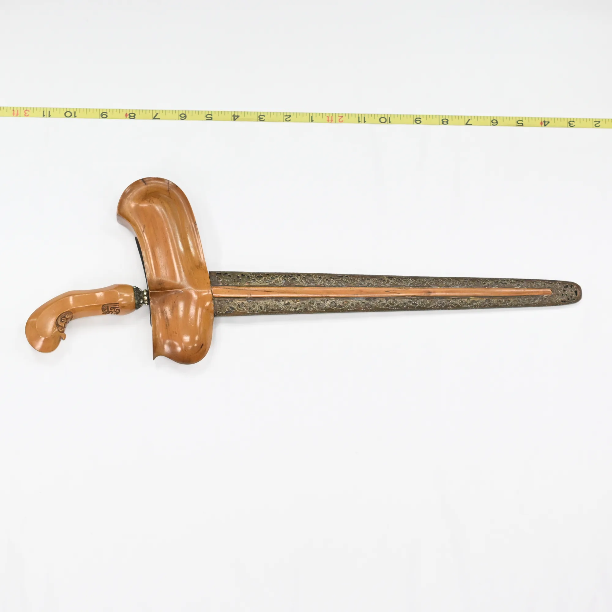 Keris dagger in its sheath with a tape measure